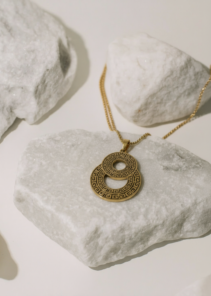 Collar Eclipse Dorado sobre pedestal de mármol