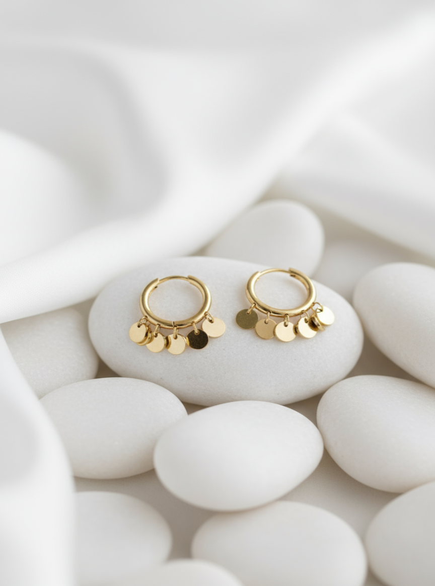 Pendientes Danza de Oriente sobre fondo de piedras y tela